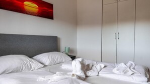 A hotel room with a large bed, a grey headboard, white bedding, and a wardrobe with two doors. - 1 bedroom awesome apartment in Vir (Vir)
