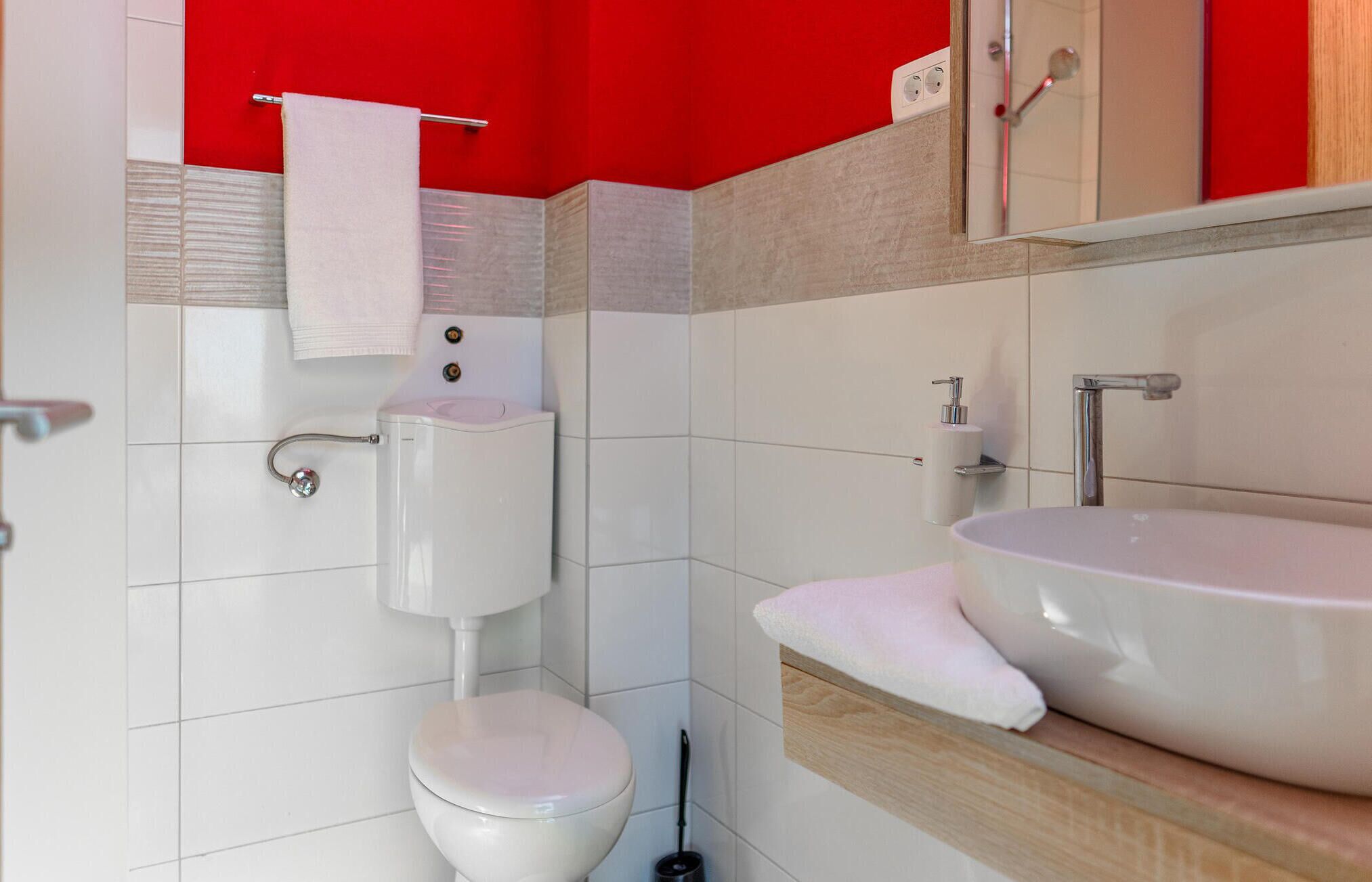 Une salle de bain avec des toilettes, un lavabo et un miroir.