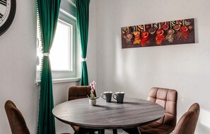 A dining area with a round table, two chairs, a clock, and a window with curtains. - Luxurious apartment in Vir with house sea view (Vir)