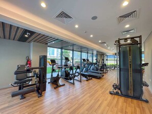 A gym with treadmills, elliptical machines, and weightlifting equipment. - Stayshort - 1 Bed in Zada Tower Sleeps 3 With Balcony (Dubai)