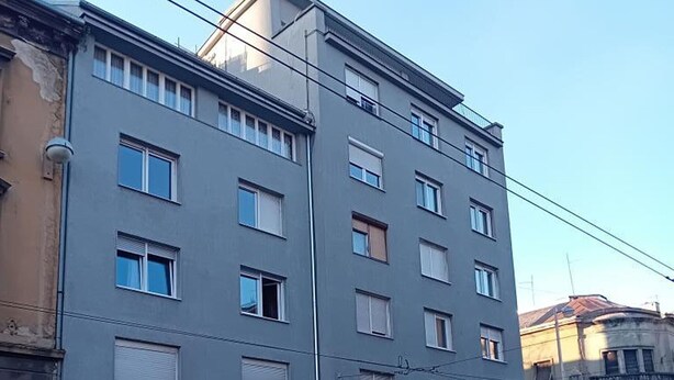 En byggnad med flera våningar och en modern arkitektonisk stil, med ett platt tak och rektangulära fönster.