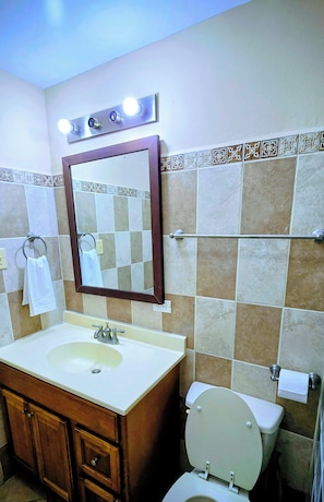 A bathroom with a sink, mirror, towel rack, and toilet. - Paradise Apartment and Single Room (San Pedro)