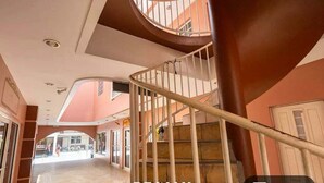 Eine Wendeltreppe mit Metallgeländer, die zu einer oberen Etage führt.