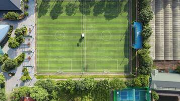 An aerial view of a soccer field surrounded by trees and buildings.