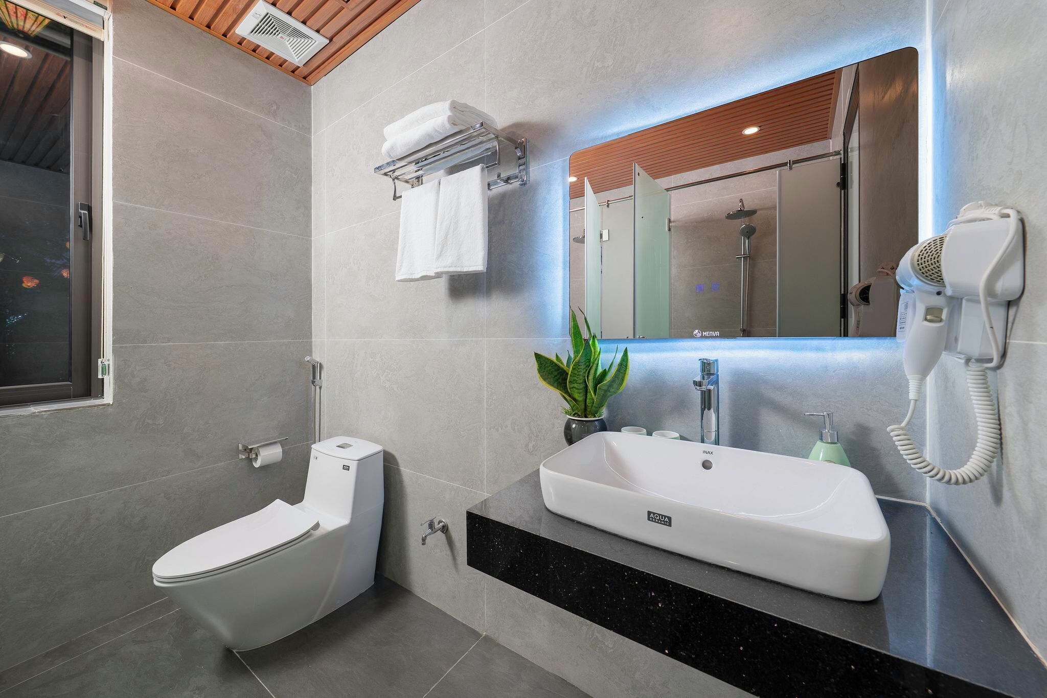 Een moderne badkamer met toilet, wastafel en spiegel.
