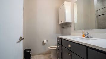 Een douche, handdoeken, zeep, toiletpapier