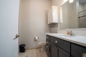 Een douche, handdoeken, zeep, toiletpapier