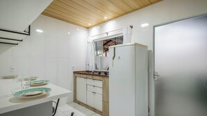 A modern kitchen with white cabinets, a wooden ceiling, and a built-in stove. - Complete House Just Minutes From the Beach Jcs0874 (Penha)