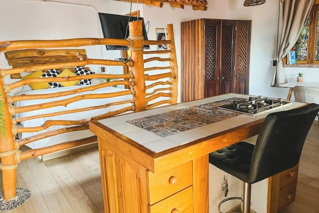 Una cocina con una isla de madera, una silla negra y un salpicadero con diseño.