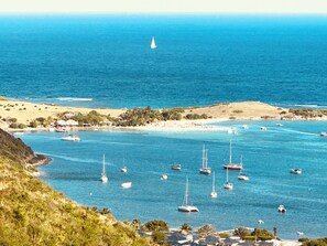 A coastal bay with multiple sailboats anchored in clear blue waters. - Sea view 1-bedroom LUXURY and cosy apartment in beautiful Orient Bay with AC (Saint Martin)
