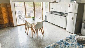 A compact kitchen with white cabinets, a stove, and a refrigerator. - Beachfront Studio in PV (Puerto Vallarta)