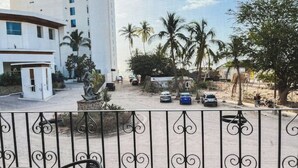 A hotel with a modern design, featuring a curved structure and a tall building in the background. - Beachfront Studio in PV (Puerto Vallarta)