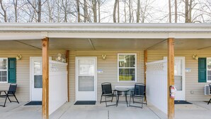 A motel with two doors, each with a small table and chair, and a covered patio area. - Cozy Couple’s Getaway Near Cataloochee Ski Area! (Waynesville)