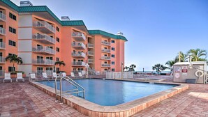 Ein Hotel mit Schwimmbad, mehreren Balkonen und einer gepflasterten Terrasse.