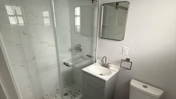 Suite, terras | Badkamer | Een douche, een haardroger, handdoeken, zeep