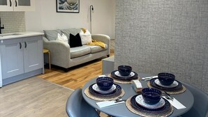 Une cuisine moderne avec des meubles blancs et un mur gris à texture.