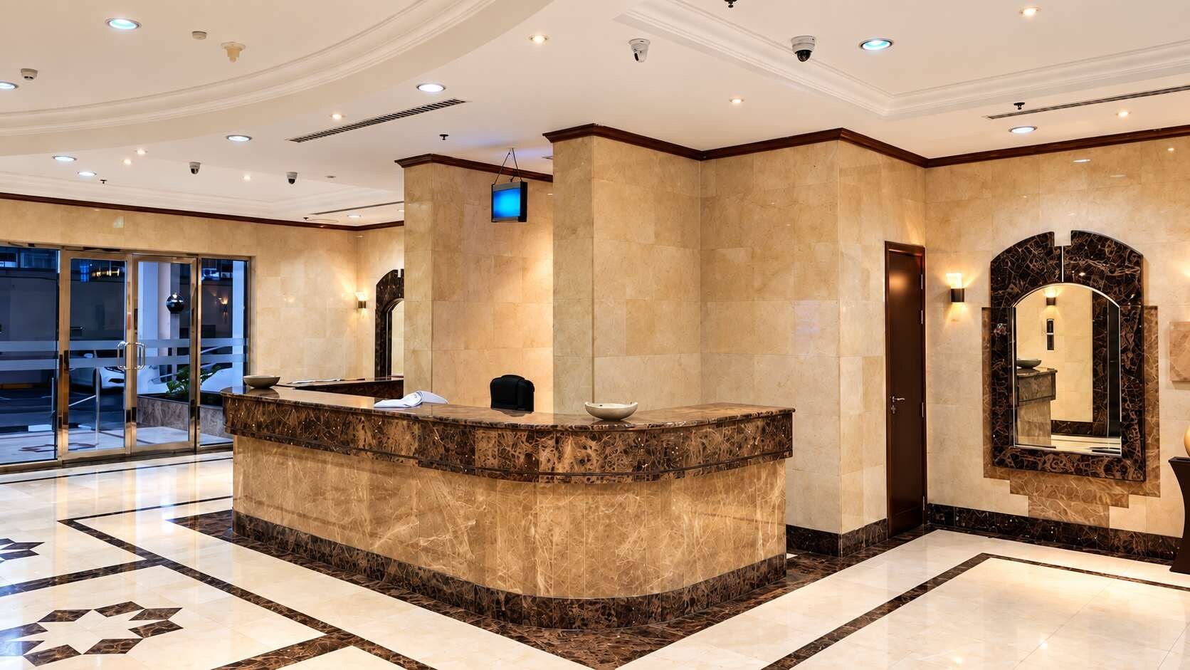 A reception area with a marble counter, a large mirror, and a glass door leading outside.