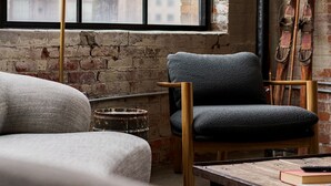 A room with a large window, a chair, a lamp, and a table with books. - The SOHO Industrial Loft (Columbus)