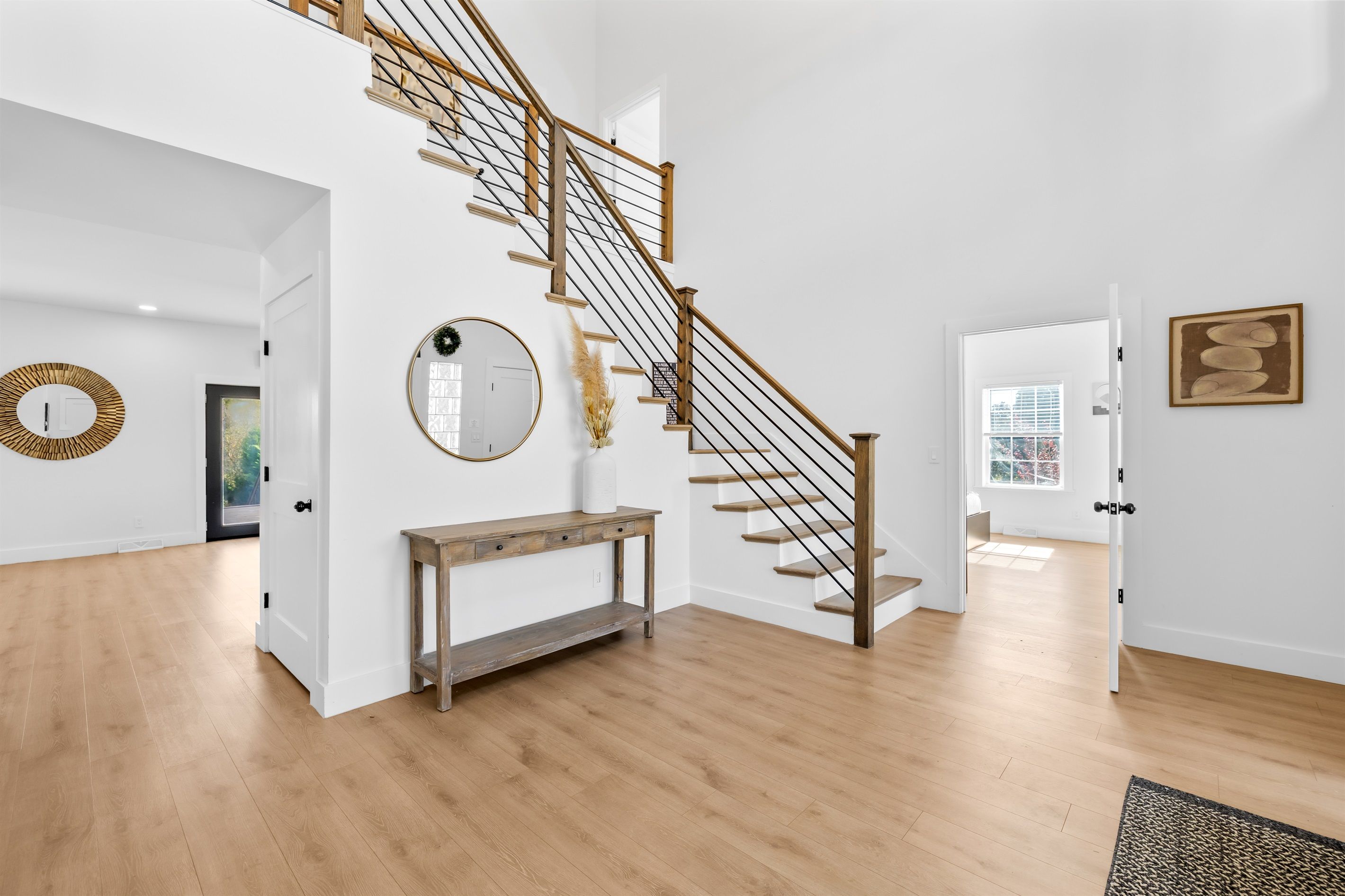 Un intérieur moderne avec un escalier en bois, des murs blancs et un plancher en bois.