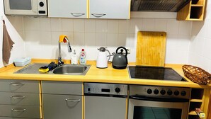 Une cuisine compacte équipée d’un four à micro-ondes, d’une bouilloire, d’un grille-pain et d’un four.