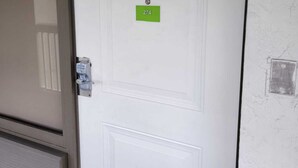 Uma porta branca com uma placa verde mostrando o número 274.