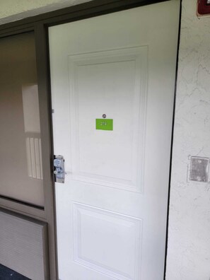 Eine weiße Tür mit einem grünen Schild, das die Nummer 274 zeigt.