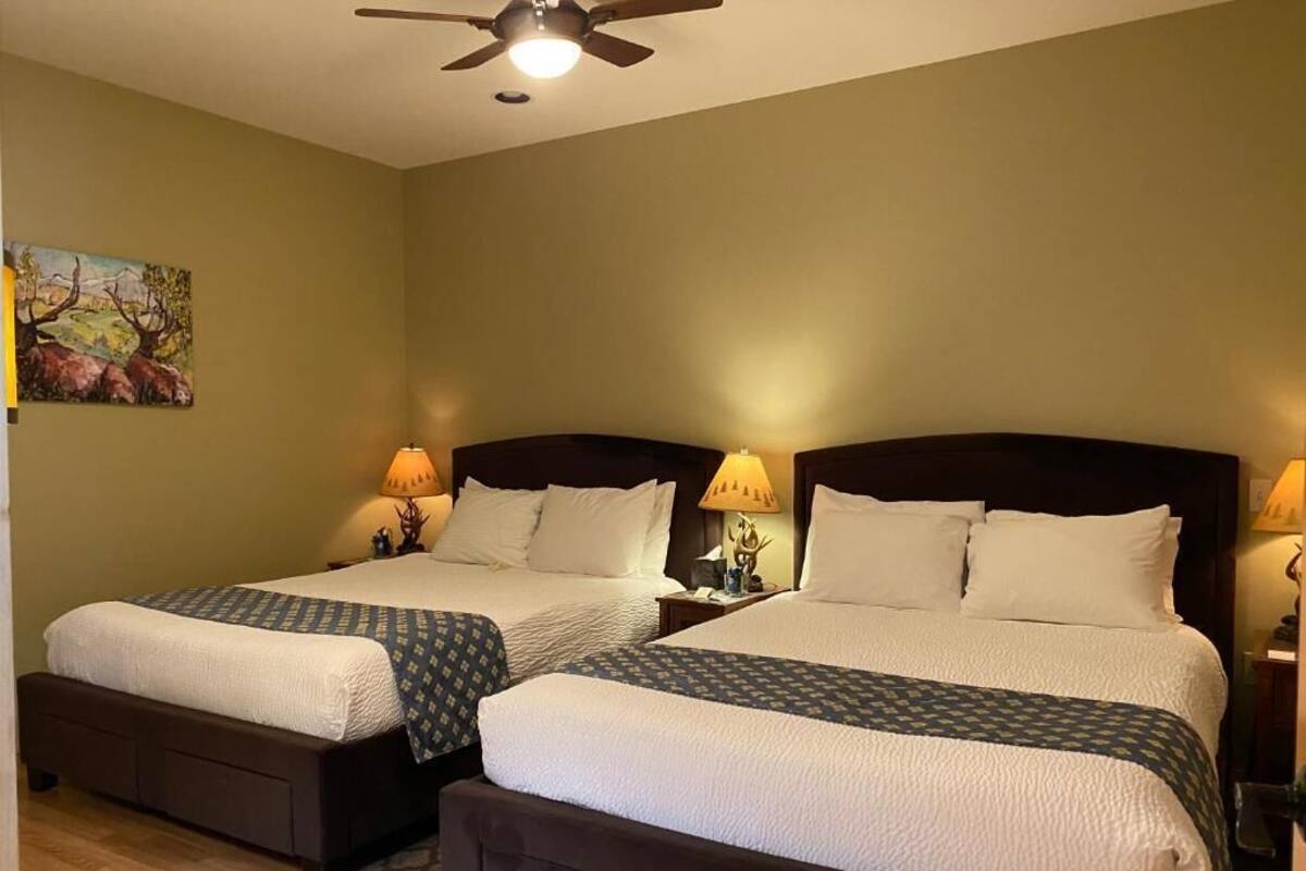 A double room with two beds, each with a headboard, bedside tables, and lamps.