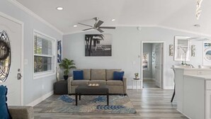 Un salon moderne avec un canapé, une table basse et un ventilateur de plafond.