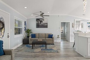 Uma sala de estar moderna com sofá, mesa de centro e ventilador de teto.