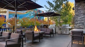 Une terrasse extérieure avec des sièges, un foyer et un barbecue.