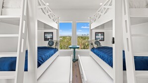 Una habitación con literas, una mesita y vistas al exterior.