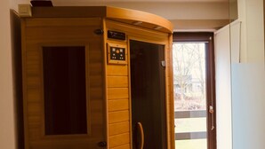 A wooden sauna with a control panel, a door, and a view of the outside. - Quiet gîte between hills and forest. Sauna and pets welcome. (Bièvre)
