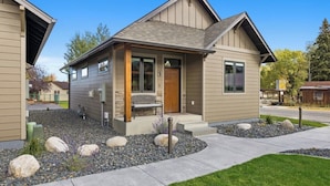 A modern two-story house with a front porch, a stone pathway, and a well-maintained lawn. - Newly Built 1BR Cottage - Rock Creek Cottages #5 (Red Lodge)
