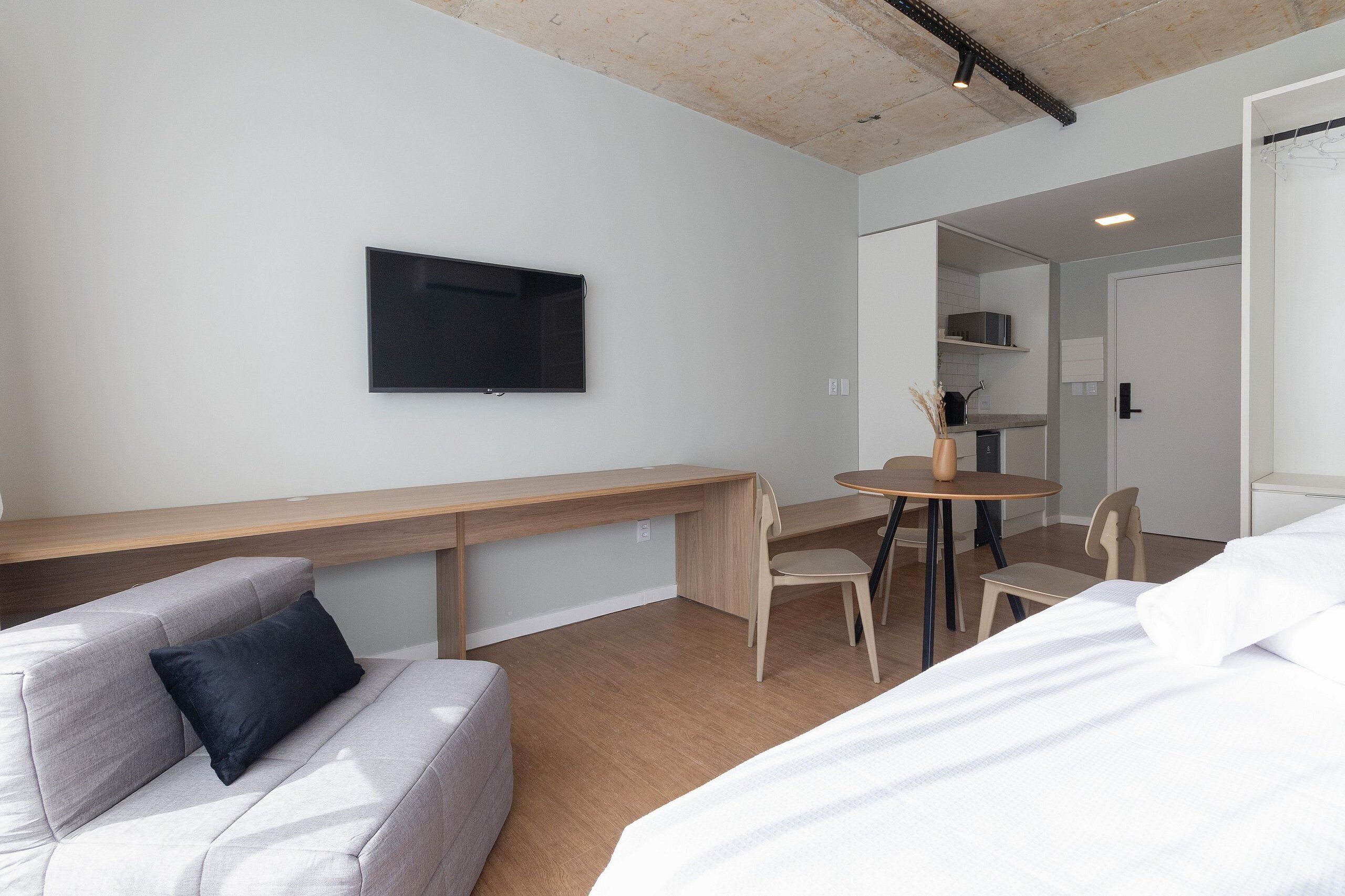Ein modernes Hotelzimmer mit Bett, Sofa, Schreibtisch und Essecke.