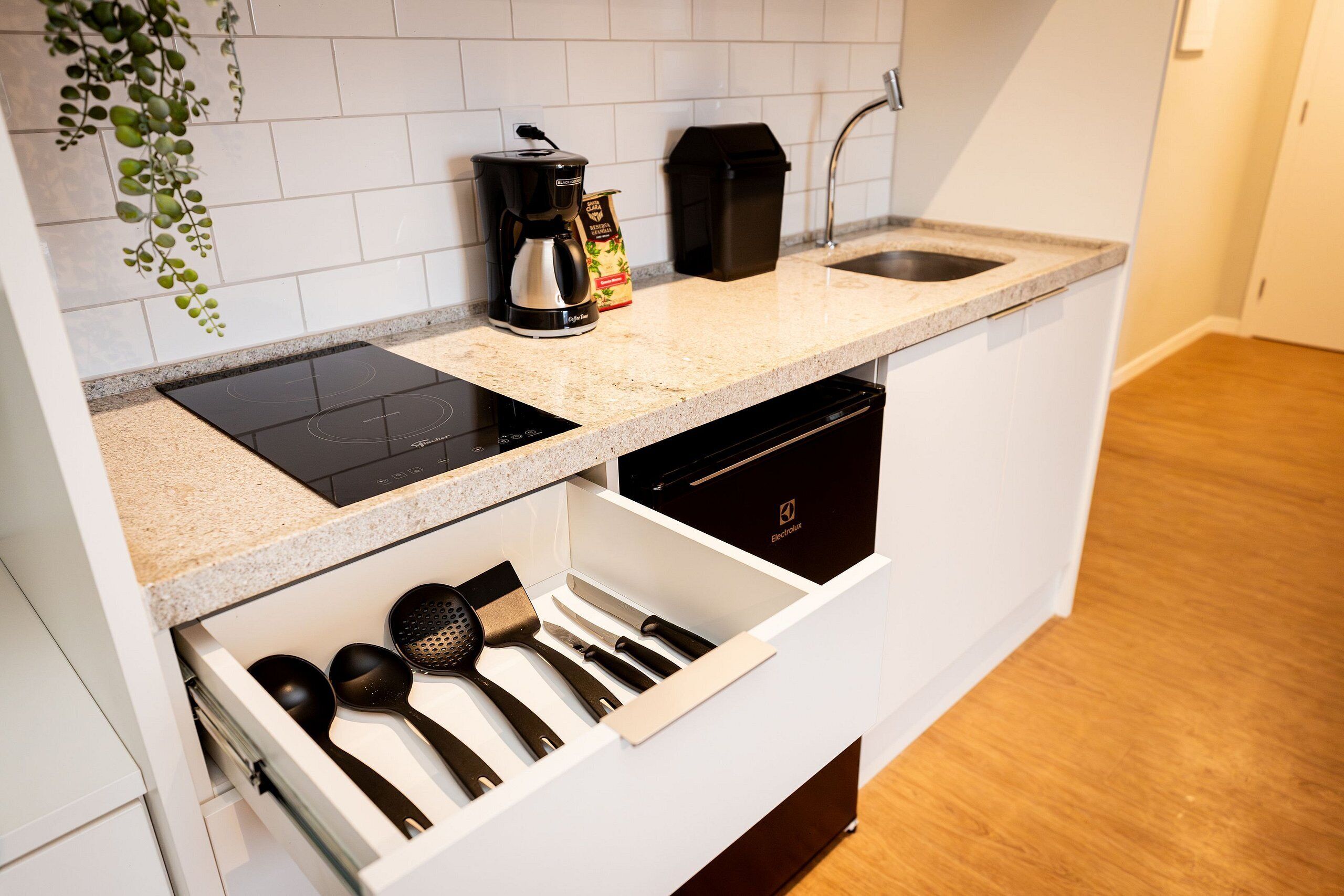A kitchen with a built-in stovetop, a coffee maker, and a dishwasher.