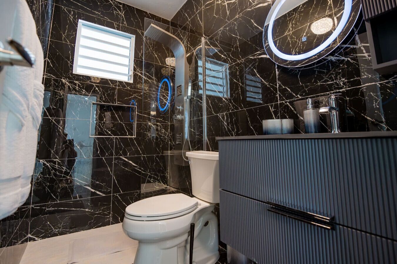A modern bathroom with a toilet, vanity, and a shower enclosure.