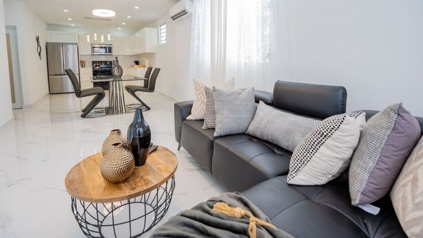 A modern living room with a sofa, coffee table, and decorative items. - La Casa Blanca [Unit #1 Machete] (Carolina)