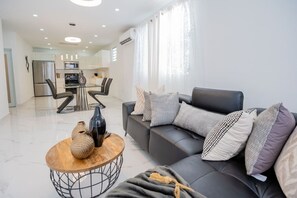 Ein modernes Wohnzimmer mit Sofa, Couchtisch und Dekorationselementen.