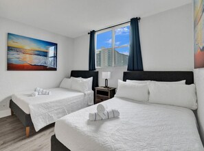 A hotel room with two beds, a painting of a sunset, a window with curtains, and a nightstand with a lamp. - Elegant Beachside Resort-Style Condo in Hollywood (Hollywood)