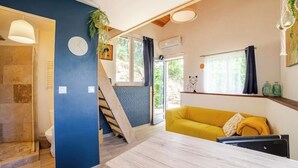 A modern living space with a staircase, a yellow sofa, a wooden table, and a clock on the wall. - Cottage in the countryside - A haven of peace in Provence Verte [LA K-LINE] [LA K-LINE (Entrecasteaux)