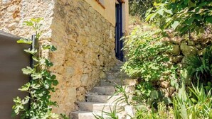 A stone staircase leading up to a building with a blue door, surrounded by greenery and plants. - Cottage in the countryside - A haven of peace in Provence Verte [LA K-LINE] [LA K-LINE (Entrecasteaux)