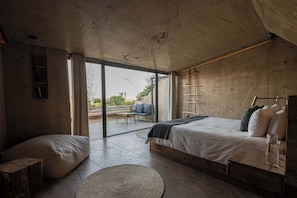 Een moderne slaapkamer met een groot bed, een houten trapje en uitzicht op de omgeving.