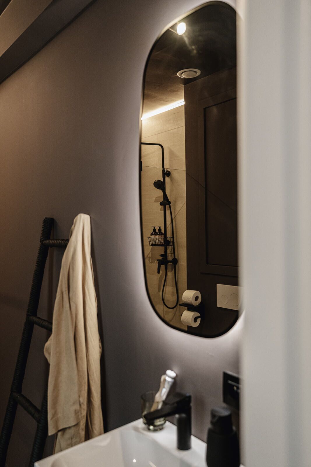 Een badkamer met een douche, een handdoekhouder en een wastafel.