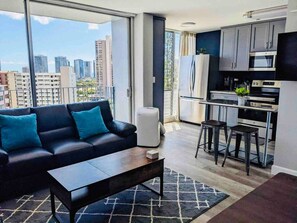 Un apartament modern amb saló, cuina i balcó.