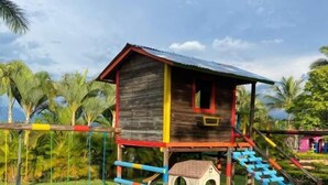 A wooden playhouse with a red roof and a small doghouse attached. - Hotel San Antonio del Cerro (Pereira)