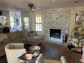 A living room with a sectional sofa, a fireplace, a Christmas tree, and a ceiling fan. - Walk to the Grove!From this 3BR 2 Bath!! (Oxford)