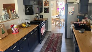 A kitchen with dark cabinets, a stove, and a microwave. There is a wooden countertop and a rug on the floor. - Walk to the Grove!From this 3BR 2 Bath!! (Oxford)