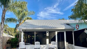 A hot tub with lounge chairs, a covered patio, and a lifebuoy on the wall. - Wonderful 3-bedroom house in St. Augustine, close to beach and Historic District (St. Augustine)