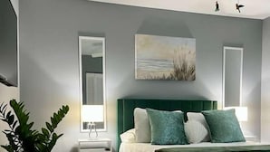 A modern bedroom with a green bed, a ceiling fan, and a large window. - Wonderful 3-bedroom house in St. Augustine, close to beach and Historic District (St. Augustine)