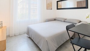 Et moderne hotelværelse med en stor seng, et skrivebord og en stol.